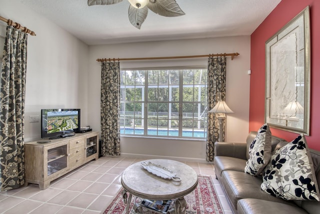 living room featuring a textured ceiling, baseboards, a ceiling fan, and light tile patterned flooring