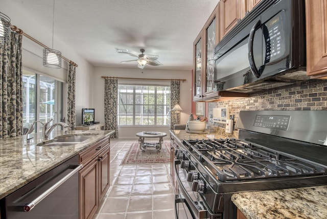 kitchen featuring black appliances, brown cabinetry, a sink, and glass insert cabinets