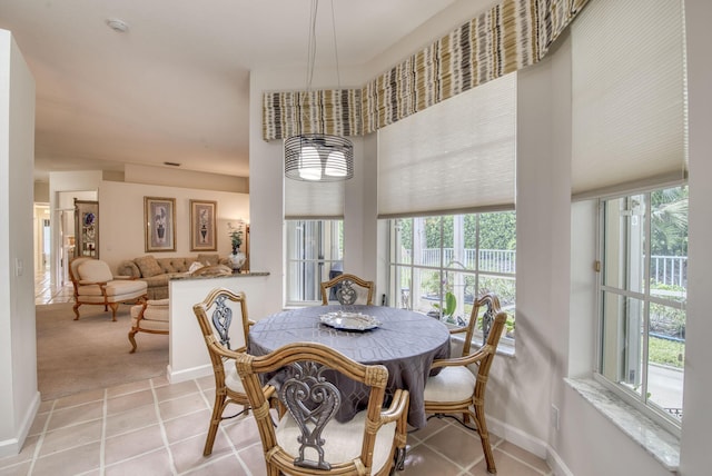 dining room with light tile patterned floors, light carpet, and baseboards