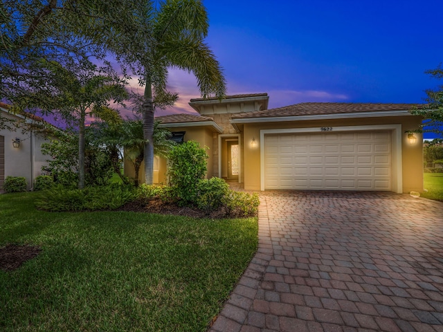 view of front of property featuring a yard and a garage