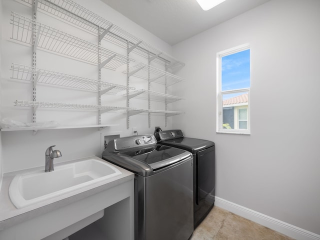 laundry room featuring washer and dryer, sink, and light tile patterned flooring