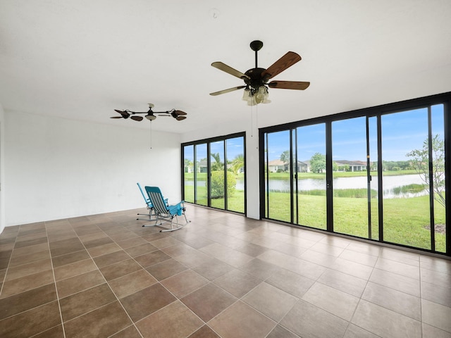 spare room with plenty of natural light, a water view, and ceiling fan