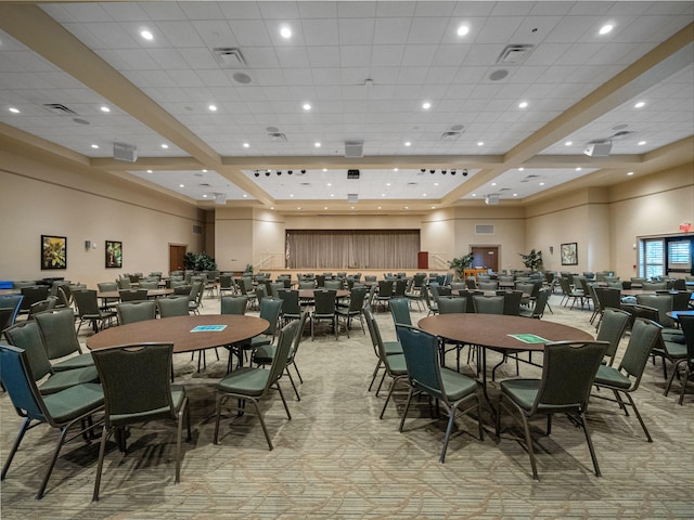 dining area featuring a high ceiling, a paneled ceiling, and light carpet