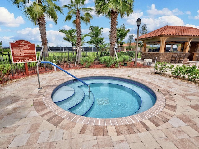 view of pool featuring a community hot tub, a patio area, and a gazebo