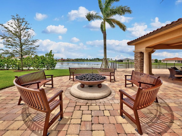 view of patio featuring an outdoor fire pit and a water view