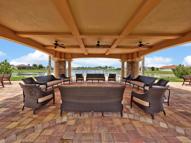 view of patio featuring outdoor lounge area, ceiling fan, and a water view