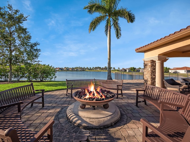 view of patio / terrace with an outdoor fire pit and a water view