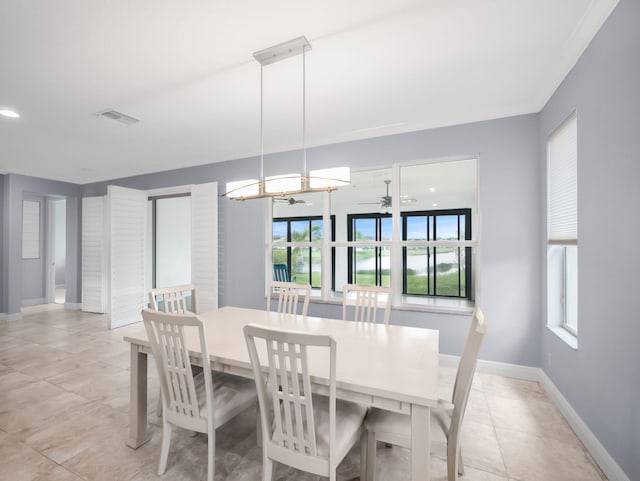 tiled dining room featuring ceiling fan and crown molding