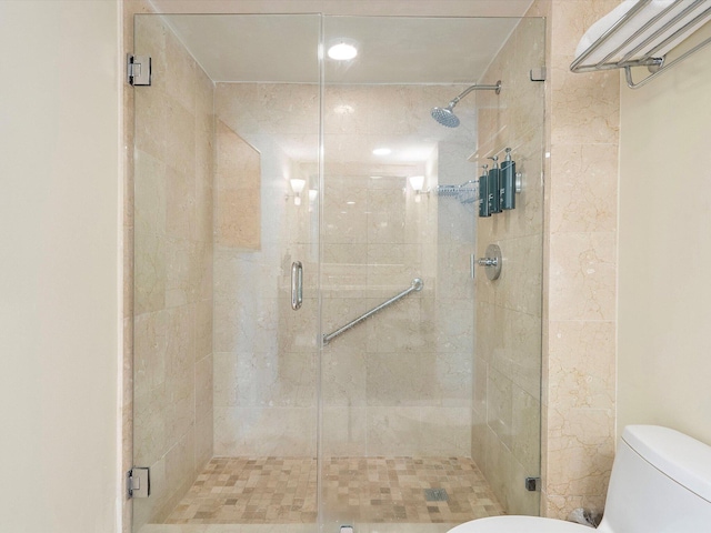 bathroom with toilet and a shower with shower door