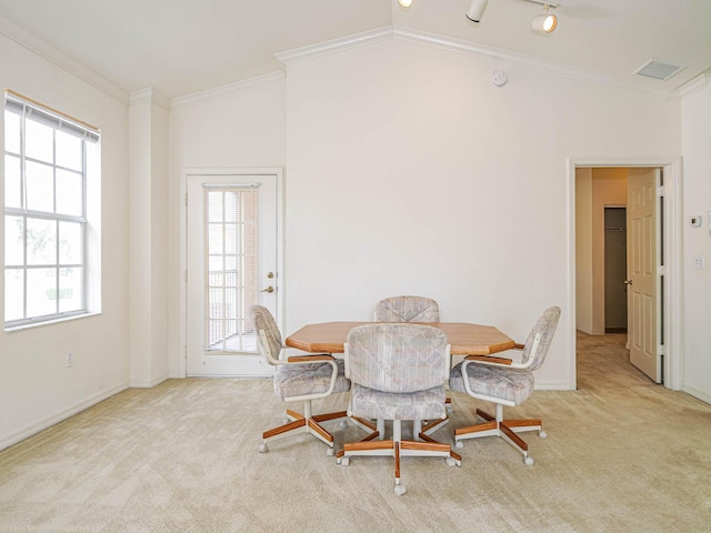 carpeted dining room with crown molding and lofted ceiling