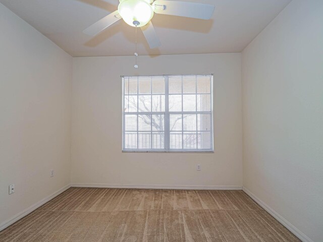 carpeted spare room with ceiling fan