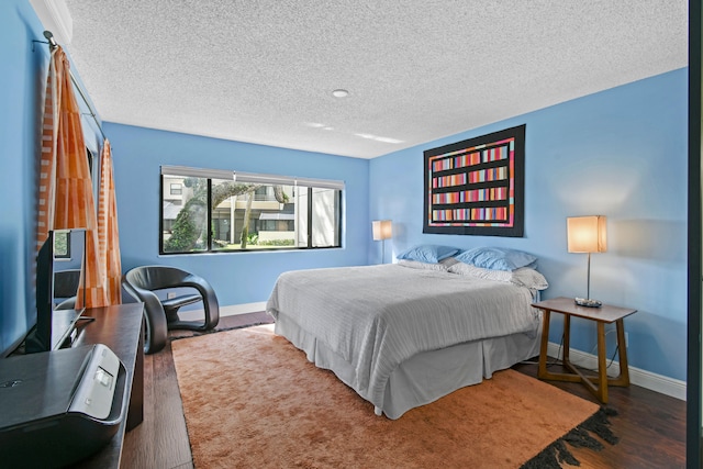 bedroom featuring a textured ceiling and dark wood-type flooring