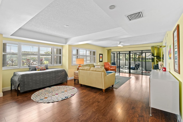 living room featuring ceiling fan, dark hardwood / wood-style flooring, and a textured ceiling