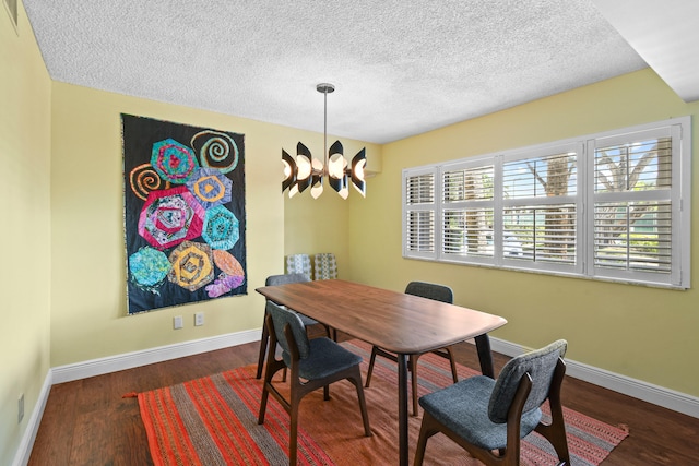 dining space with dark hardwood / wood-style floors, a notable chandelier, and a textured ceiling