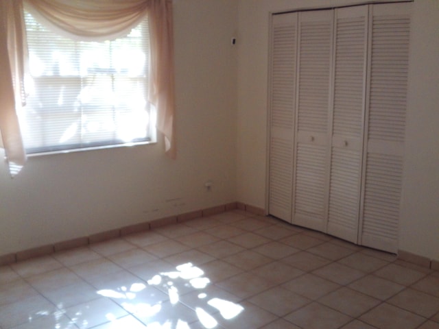 unfurnished bedroom with a closet and light tile patterned floors