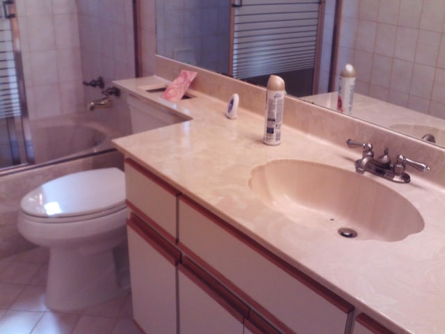 full bathroom featuring vanity, toilet, tile patterned floors, and bath / shower combo with glass door