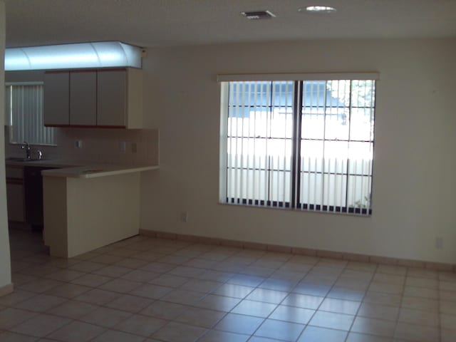 interior space with light tile patterned floors, tasteful backsplash, and sink