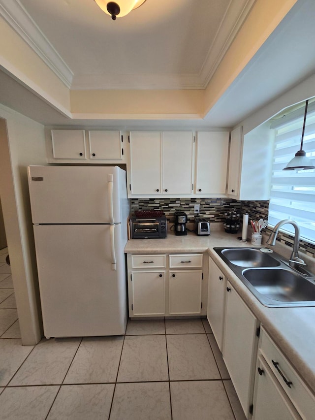 kitchen featuring white cabinets, light tile patterned floors, sink, white fridge, and ornamental molding