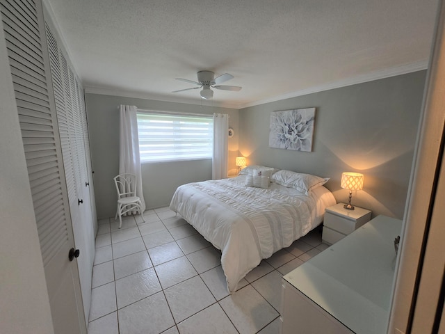 bedroom featuring a closet, ceiling fan, light tile patterned floors, and ornamental molding