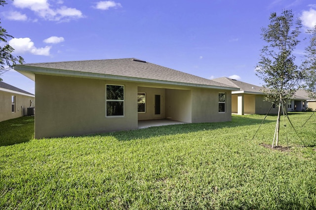 back of house with cooling unit, a patio area, and a lawn