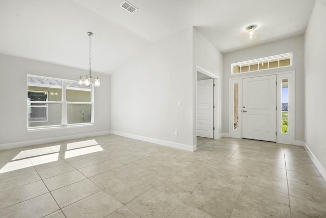 foyer entrance featuring light tile patterned floors, an inviting chandelier, and plenty of natural light