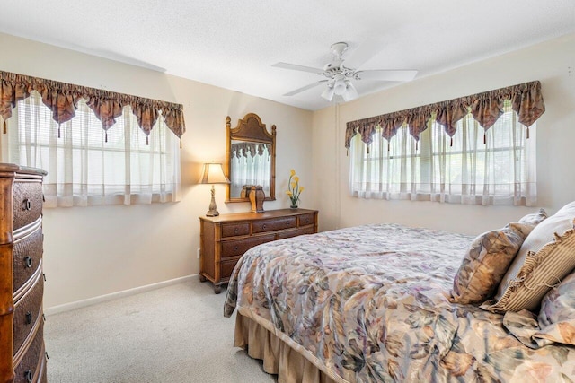 carpeted bedroom with ceiling fan and a textured ceiling