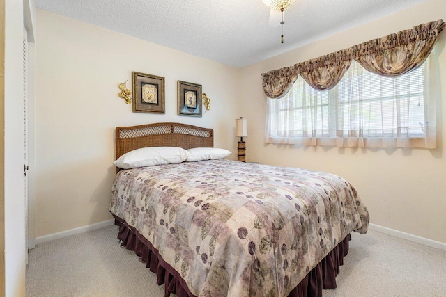 bedroom featuring ceiling fan, carpet floors, and a textured ceiling