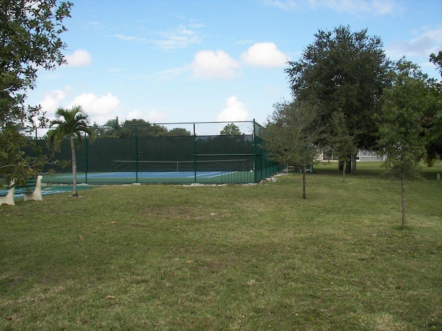 view of tennis court with a lawn