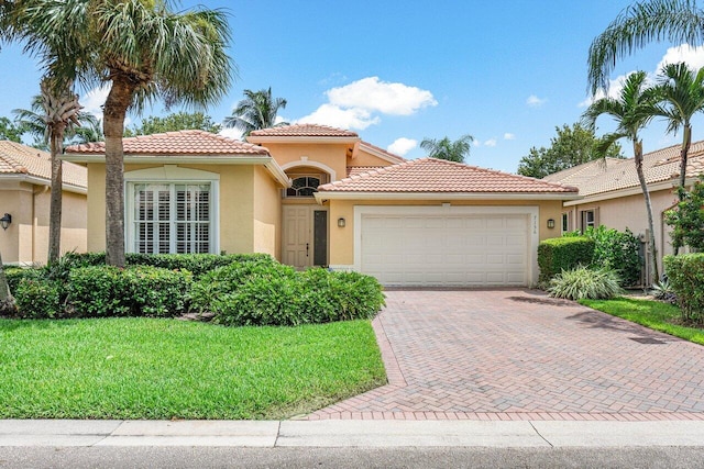 mediterranean / spanish-style home featuring a garage and a front lawn