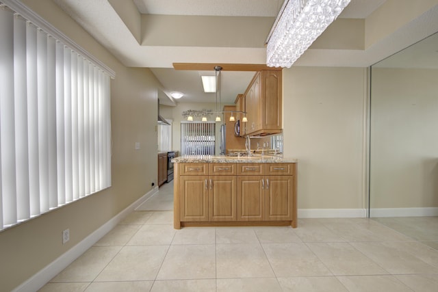 kitchen with light stone countertops, light tile patterned floors, and decorative light fixtures