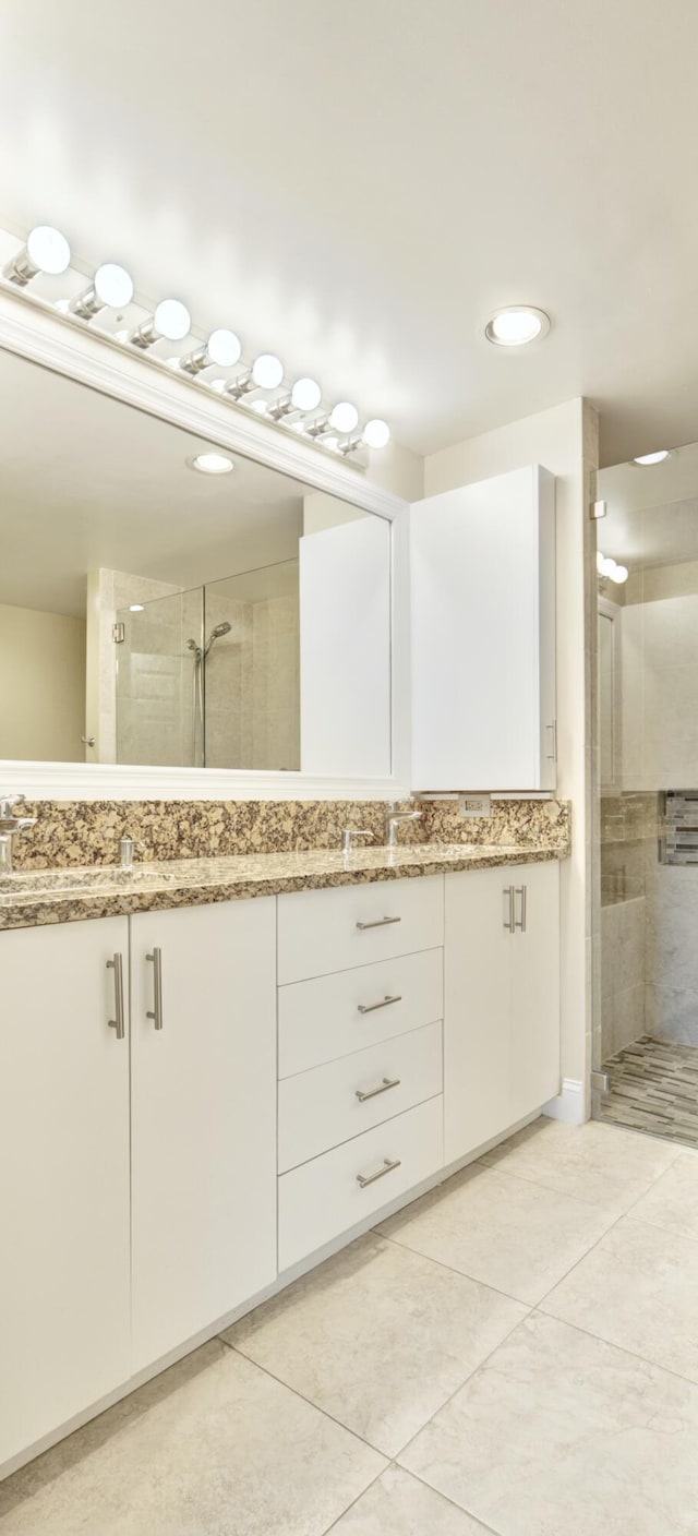 bathroom featuring tile patterned flooring, vanity, and walk in shower