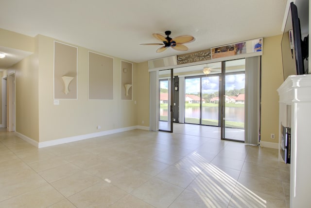 unfurnished room with a water view, ceiling fan, and light tile patterned floors