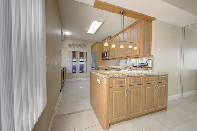 kitchen featuring sink, light stone countertops, light tile patterned floors, decorative light fixtures, and stainless steel appliances