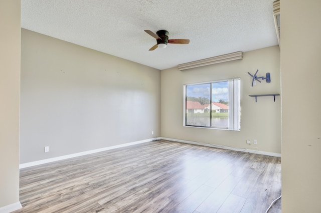 unfurnished room with ceiling fan, light hardwood / wood-style flooring, and a textured ceiling