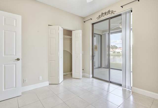 unfurnished bedroom featuring light tile patterned flooring, access to outside, and a closet