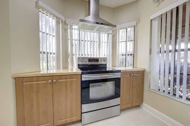 kitchen with stainless steel electric stove, light tile patterned floors, and island exhaust hood