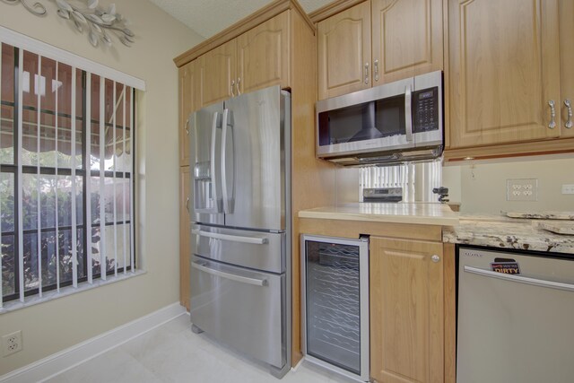 kitchen with wine cooler, light brown cabinetry, light tile patterned floors, and stainless steel appliances