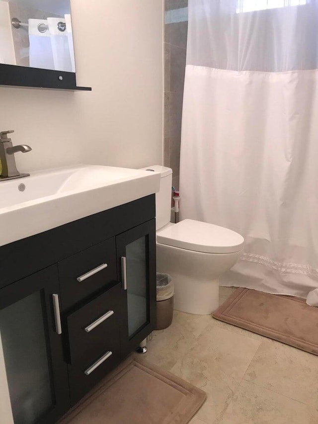 bathroom with vanity, toilet, tile patterned floors, and walk in shower