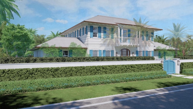 view of front of property with a gate, stucco siding, fence private yard, and a balcony