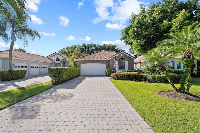 mediterranean / spanish home featuring a garage and a front lawn