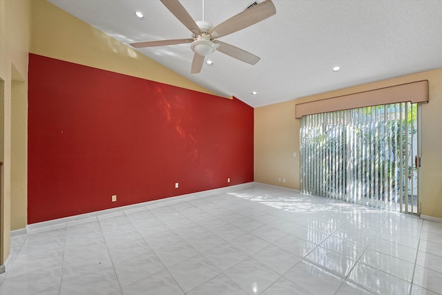 tiled empty room with a textured ceiling, vaulted ceiling, and ceiling fan