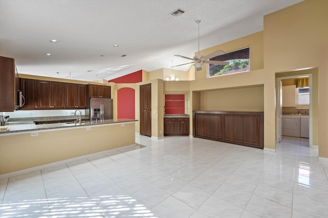 kitchen with appliances with stainless steel finishes, independent washer and dryer, high vaulted ceiling, a textured ceiling, and ceiling fan