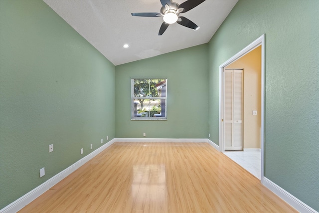 empty room with light wood-type flooring, vaulted ceiling, and ceiling fan