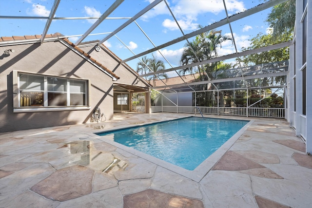 view of pool with glass enclosure and a patio