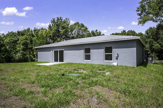 3534 NW 32nd Ave, Okeechobee, FL 34972 - back of house with central AC, a yard, and stucco siding