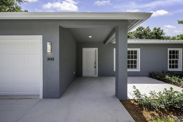 3534 NW 32nd Ave, Okeechobee, FL 34972 - doorway to property with stucco siding and an attached garage