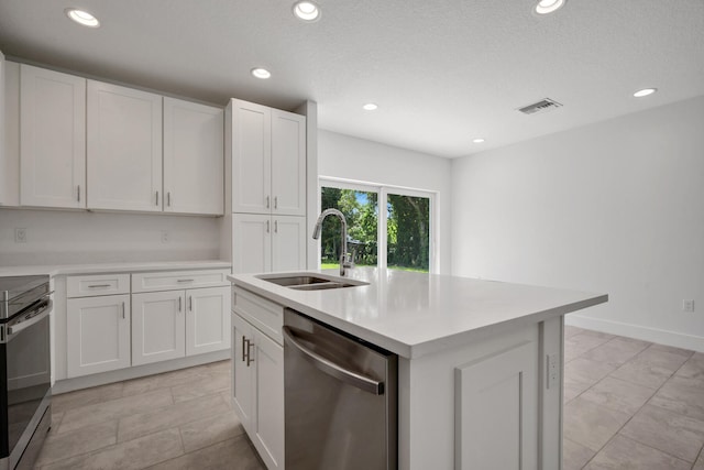 kitchen featuring light tile patterned floors, appliances with stainless steel finishes, an island with sink, sink, and white cabinetry