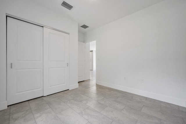 unfurnished bedroom featuring light tile patterned floors and a closet