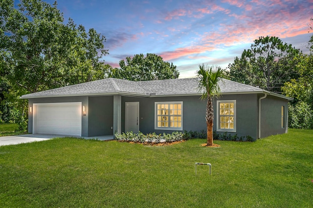 view of front of house with a garage and a yard