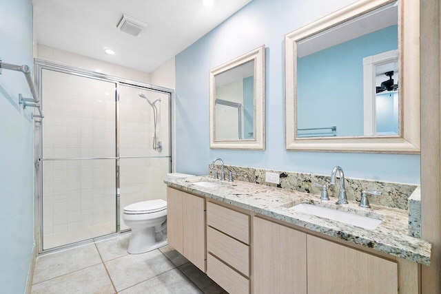 bathroom with vanity, toilet, a shower with shower door, and tile patterned flooring